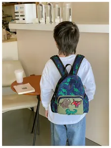 Dettaglio dello zaino blu navy con dinosauri per bambini e toppe a cartone animato