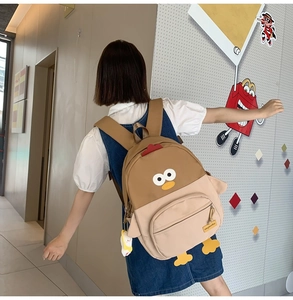 Detail of cute cartoon chick backpack featuring 3D wings and adjustable shoulder straps