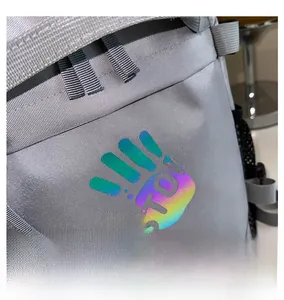 Detail of grey nylon backpack featuring a colorful reflective STOP hand print and punk label