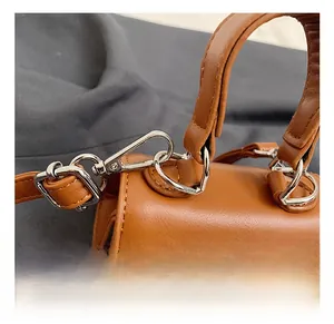 Detail view of mini leather handbag showing silver hook and refined stitching quality