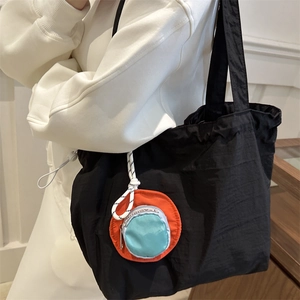 Schwarze Nylon-Tragetasche für Kinder mit orangefarbenem Anhänger im japanischen Stil