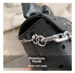 Close-up of silver chain strap and metal carabiner hook on the polka dot handbag
