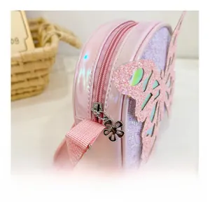 Detail of pink pearlescent kids crossbody bag featuring sequined butterfly wing and petal zipper