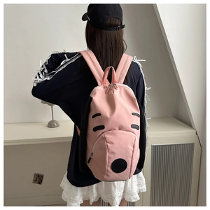 Detail of pink Snoopy-style backpack with black long ears and cute cartoon facial features