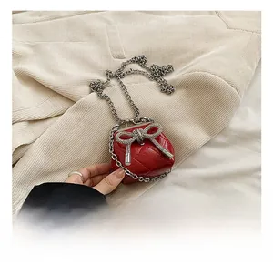 Dettaglio della mini borsa trapuntata rossa con catena e fiocco di strass scintillanti