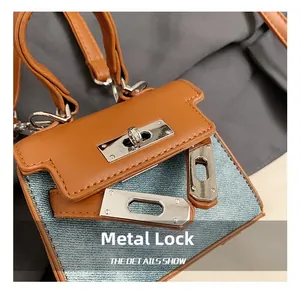 Detailed macro view of silver metal twist lock on caramel leather and denim mini bag