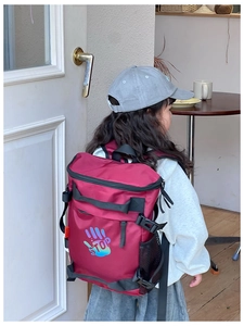 Detail of burgundy kids backpack with colorful palm print and adjustable side buckles