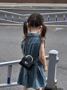 Détail du mini sac noir pailleté pour fille avec anse en perles et fermoir coeur