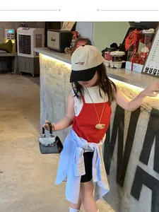 Kids mini crossbody bag styled with trendy summer outfit including cap and red top