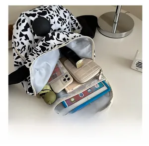 Internal view of cow print canvas backpack showing storage capacity for tablet and essentials