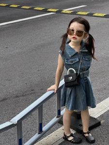 Détail d'un mini sac noir pailleté avec une poignée en perles et un fermoir coeur en métal