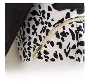 Close-up of smooth zipper closure on a cow print backpack with durable fabric texture