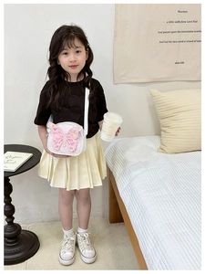 Girl wearing a shiny glitter butterfly crossbody bag with adjustable white shoulder strap