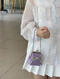 Dettaglio borsa trapuntata viola da bambina con fiocco di strass e catena d'argento