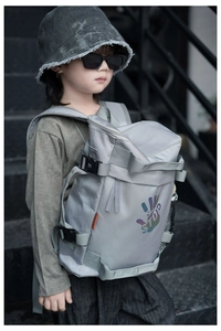 Detail view of dark grey kids backpack featuring stop print and side buckle straps