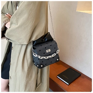 Close-up of vintage polka dot bag featuring a large black bow and silver twist lock