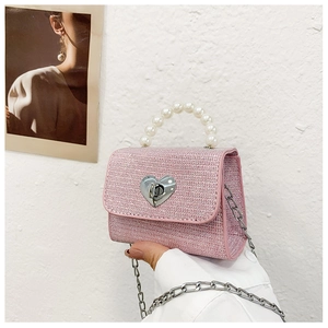 Détail du tissage rose scintillant et fermoir cœur sur le mini sac à perles