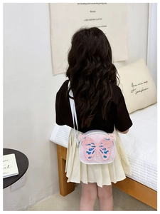 Rear view of a child wearing a pink butterfly crossbody bag with shiny sequins decor