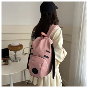 Side view of cute pink puppy backpack with long black ears for school and travel