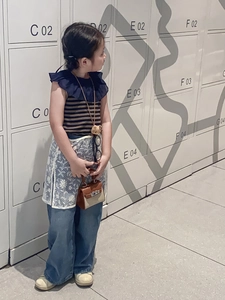 Close-up of a stylish contrast color mini handbag for children paired with kids denim