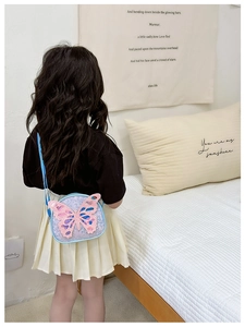 Detail of a round blue kids crossbody bag with a large pink sequined butterfly