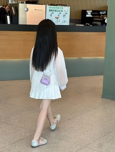 Dettaglio della borsa a tracolla trapuntata viola per bambina con fiocco di strass e scarpe glitter