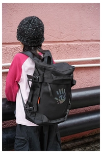 Detail of durable black kids backpack with reflective STOP logo and side buckle straps