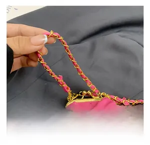 Detailansicht der rosa gesteppten Handtasche mit Schleife und goldener Kette