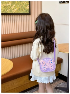 Detail of purple sequin kids crossbody bag with 3D butterfly shown on a model