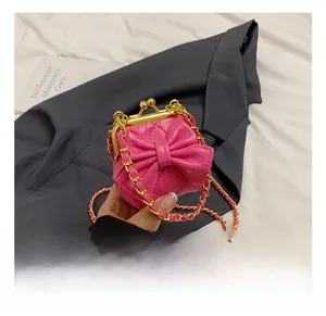 Detail der pinken gesteppten Kinder-Umhängetasche mit Schleife und Goldkette