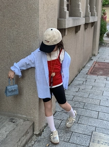 Outdoor street view of kids light blue embossed handbag and stylish urban outfit detail