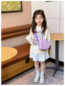 Detail of purple sequin kids crossbody bag featuring a large decorative butterfly