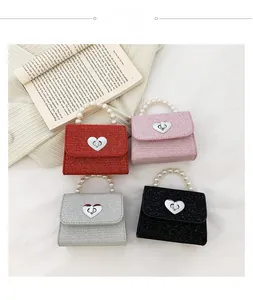 Détail de quatre mini sacs à main colorés avec poignées en perles et fermoirs cœur
