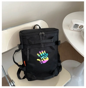 Close-up of black nylon backpack featuring colorful hand print and sturdy straps