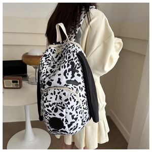 Detail of cow print backpack featuring cute long puppy ears and large storage capacity