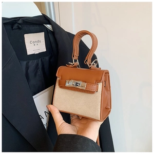 Detail of mini canvas and leather handbag with metal turn-lock clasp in contrast color