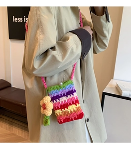 Detail der gehäkelten Regenbogen-Schultertasche mit Sonnenblumen-Anhänger und Perlenverschluss