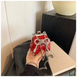 Dettaglio mini borsa trapuntata rossa con fiocco di strass e chiusura in metallo