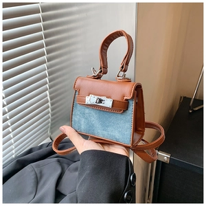 Detail of kids mini crossbody bag featuring denim leather patchwork and metal twist lock