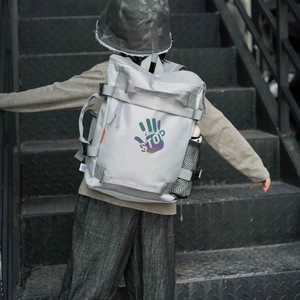Kids grey outdoor backpack with STOP graphic and matching bucket hat on stairs