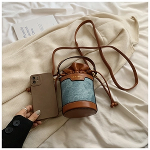 Mini bucket bag size comparison with smartphone showing its compact and trendy design