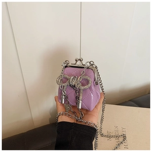 Dettaglio mini borsa viola in pelle trapuntata con fiocco di strass e catena in metallo