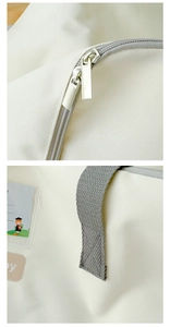 Detail of metal double zipper and grey woven handle stitching on children's canvas bag