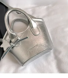 Detail of silver handbag with metallic texture, star pendant and fashion embossing