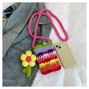 Detail der Regenbogen-Häkeltasche mit Perlenverschluss und Blumenanhänger aus Strick