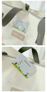 Detailed view of canvas storage bag featuring a clear name card slot and hello baby embroidery