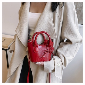 Detail of red shiny mini bucket bag with star pendant and Fashion Bag print