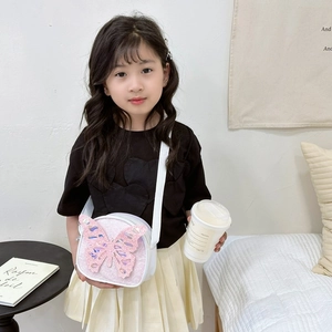 Girl's round crossbody bag featuring a pink sequined butterfly and white leather piping