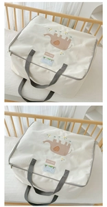 Detail of elephant embroidery and clear PVC info tag on canvas quilt storage bag