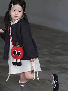 Enfant portant un sac bandoulière pomme au crochet avec yeux mignons et détails